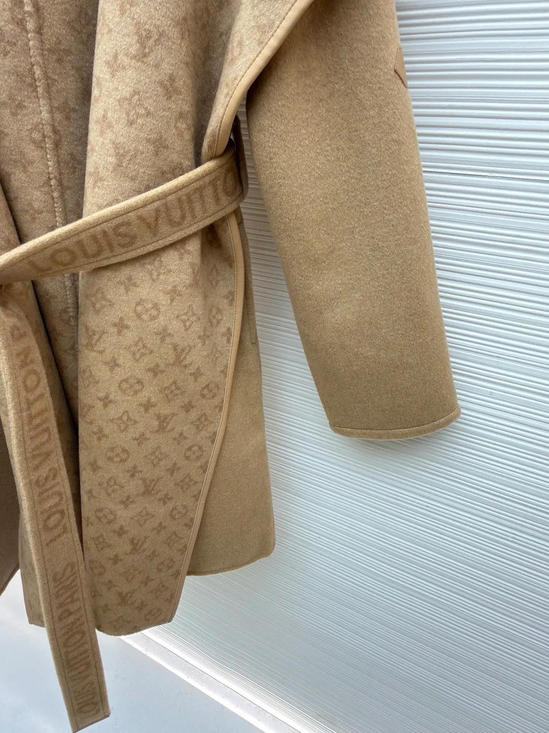 LOUIS VUITTON Wool lace-up wrap hooded coat (mid-length) ●Item number: 1682299-J025 ●Fabric: wool fabric ●Technology: jacquard production ●Color: khaki ●Version: loose fit ●Weight: about 1725 grams ●Size: 34-36-38-40 ●Description: This presbyopic wool coat is made of double-sided blended wool fabric imported from Italy. The main part is made of high-density matte black wool, which has been pre-shrunk and steam-set to ensure that the fabric is stiff and not easily deformed. The large lapel and belt areas use jacquard weaving technology to present the classic presbyopic pattern as a three-dimensional texture. The pattern is digitally positioned and plated to ensure that the texture is symmetrical and clear. The body of the garment is unlined and double-sided sewn to reduce the weight of the garment while improving skin-friendliness. The cuffs and hem are hand-stitched to reveal exquisite details. The waist is customized with a wide belt of the same fabric, with an adjustable buckle design with invisible stitching, allowing the silhouette to be freely adjusted; the neckline adopts a double-layer composite structure, combined with the fixation process of hand-made arch stitches, to make the large lapels more three-dimensional. Every splicing follows the precision sewing standard of 1cm/8 stitches, perfectly integrating craftsmanship and design aesthetics. The overall wiring is straight and delicate, the fabric is comfortable and soft, and the color is consistent without color difference. It can be matched with the same style to create a fashionable look and control various occasions. Customized accessories, complete with three standards, same style for men and women!
